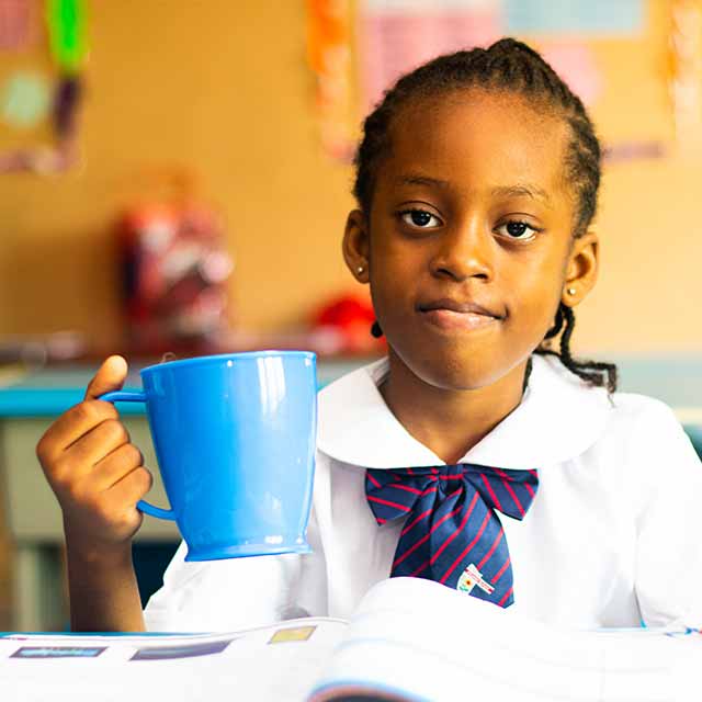 young girl with a cup of water while studing